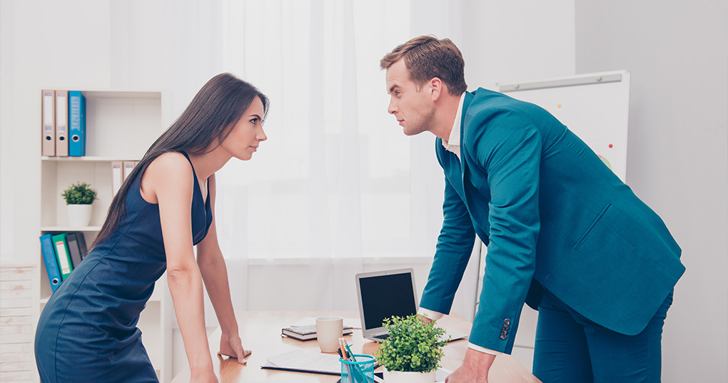 Man and woman looking confrontational in office.